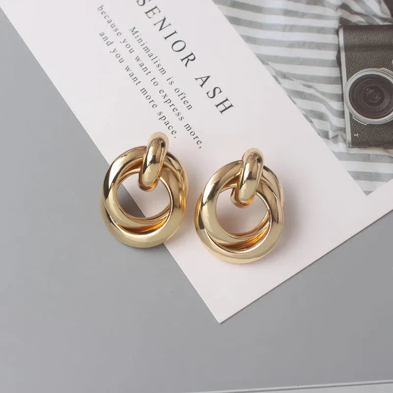 Geometric statement earrings in a luxurious gold finish, featuring a unique hollow twist design for a bold, fashionable look