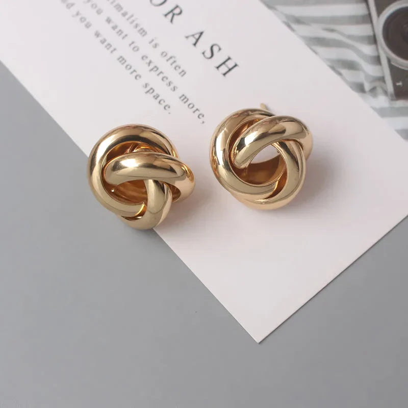 Geometric statement earrings in a luxurious gold finish, featuring a unique hollow twist design for a bold, fashionable look