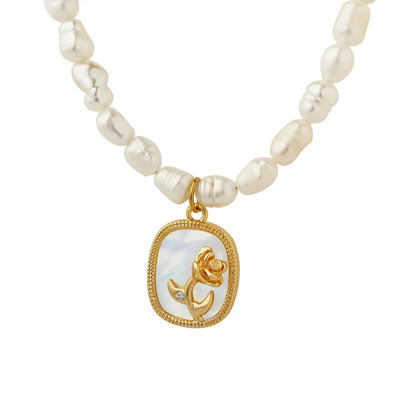 Exquisite gold-toned necklace featuring a delicate chain with embossed floral design and natural freshwater pearls accented by zirconia stones