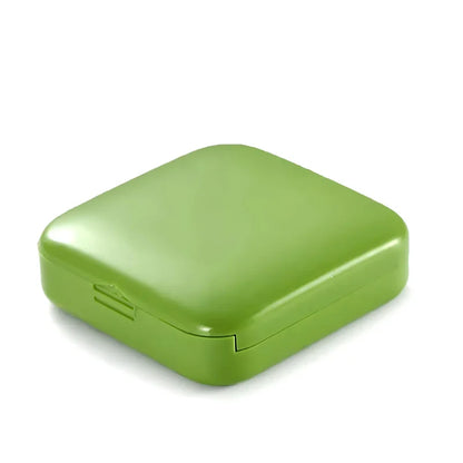 A compact, push-pull pill organiser in a vibrant green colour with cartoon-inspired design