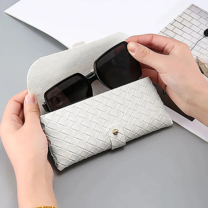 Stylish black and white twist braided leather sunglasses case with snap closure, protecting eyewear in a fashionable way