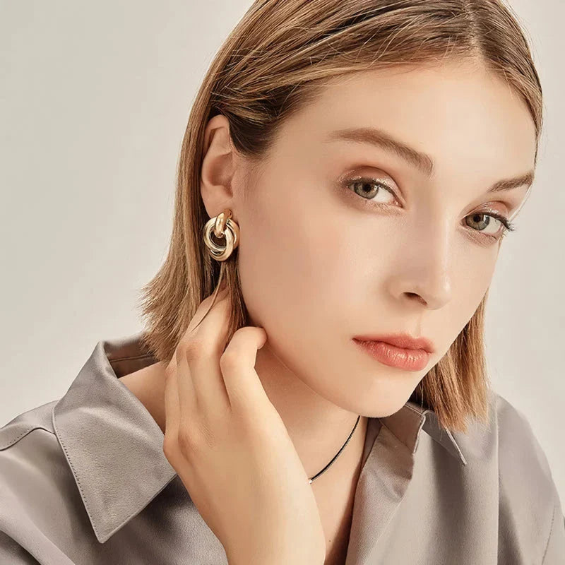 Geometric statement earrings in a luxurious gold finish, featuring a unique hollow twist design for a bold, fashionable look