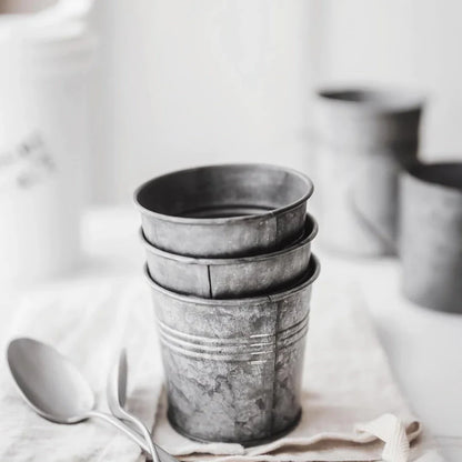 Vintage-inspired metal beverage cup with a charming wrought iron handle, perfect for serving desserts, fruits, and snacks