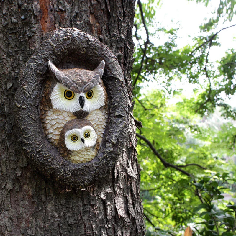 Charming resin mother and child owl ornament hanging from a tree branch in a Kiwi garden