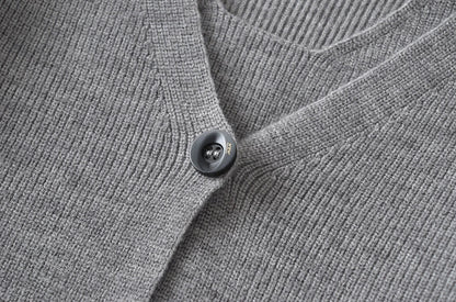 Stylish knitwear vest in a classic black or neutral colour, featuring a V-neck collar and long sleeves for a polished, versatile look.