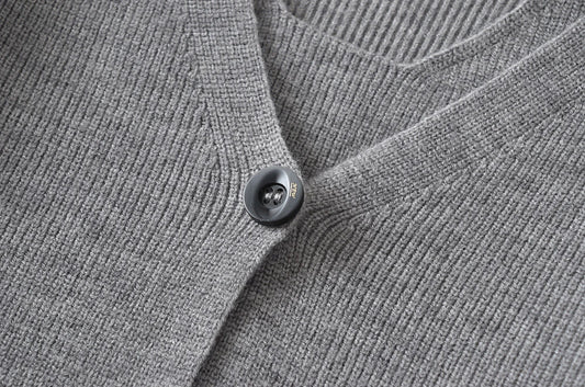 Stylish knitwear vest in a classic black or neutral colour, featuring a V-neck collar and long sleeves for a polished, versatile look.