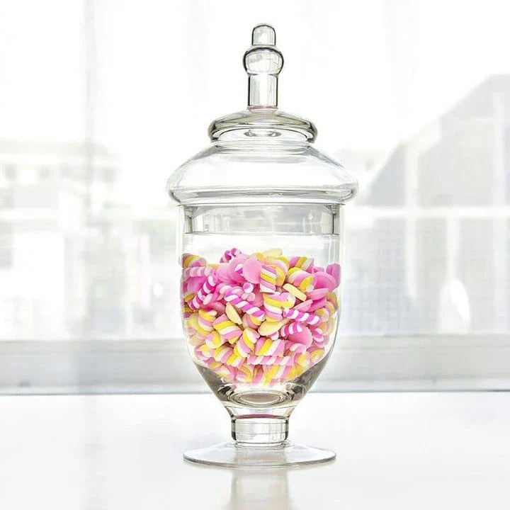 A transparent glass candy jar with a secure lid, perfect for serving sweets and treats at a wedding celebration.