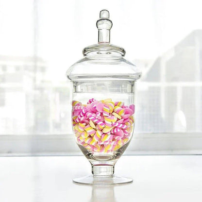 A transparent glass candy jar with a secure lid, perfect for serving sweets and treats at a wedding celebration.