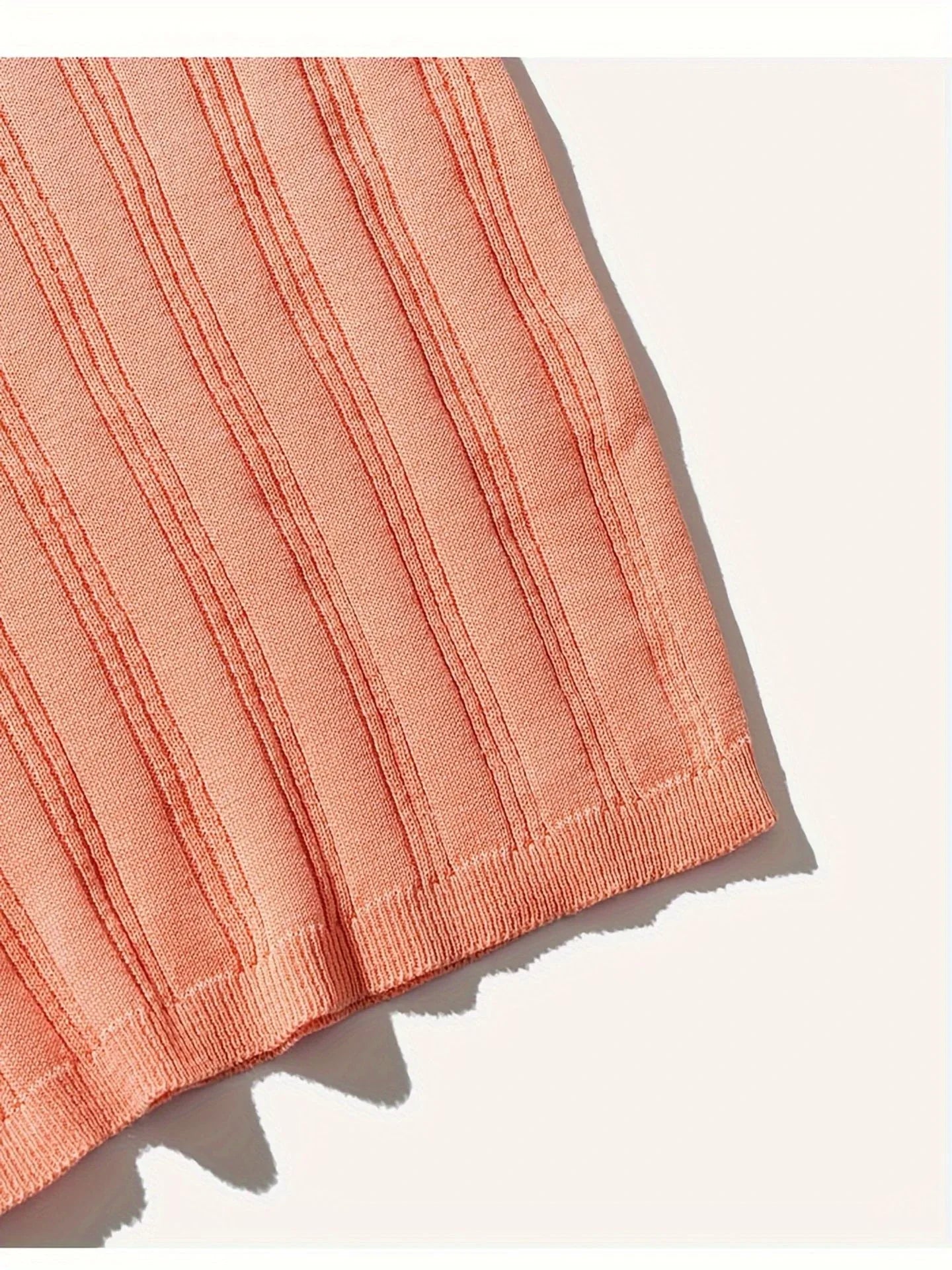 Premium Kiwi-made acrylic knitted tee in a vibrant orange-red hue, featuring a slim-fit design and classic short sleeves