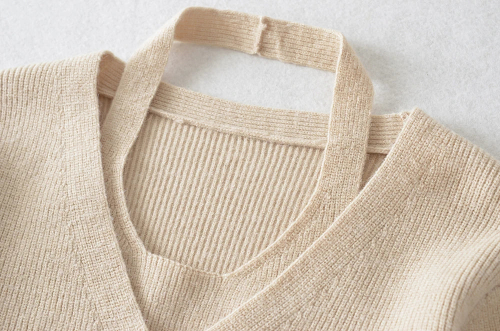 Stylish knitwear vest in a classic black or neutral colour, featuring a V-neck collar and long sleeves for a polished, versatile look.