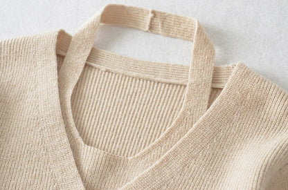 Stylish knitwear vest in a classic black or neutral colour, featuring a V-neck collar and long sleeves for a polished, versatile look.