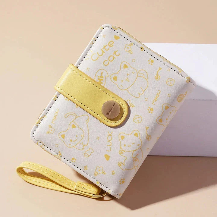 A stylish compact wallet featuring a playful cat-themed design with a tilted head motif, available in a range of candy-inspired colours.