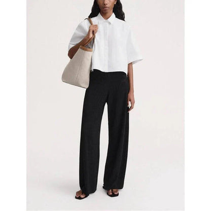 High-waist hollow-out knit trousers in a black color, featuring a straight, wide-leg cut and a sophisticated pattern