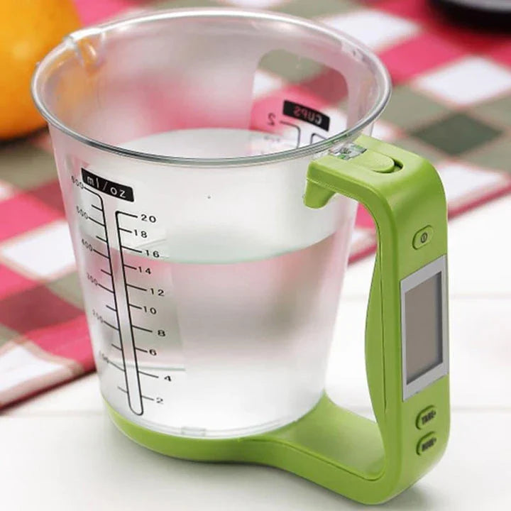 A green digital measuring cup with an LCD display integrated into the handle, designed in New Zealand for precise kitchen measurements