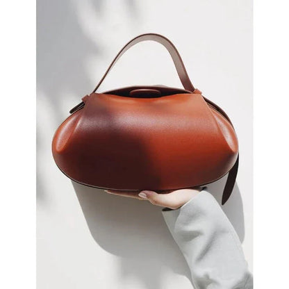 A stylish circular vegan leather handbag with a unique rugby-inspired design, perfect for Kiwi fashion enthusiasts