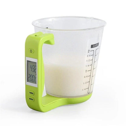 A green digital measuring cup with an LCD display integrated into the handle, designed in New Zealand for precise kitchen measurements