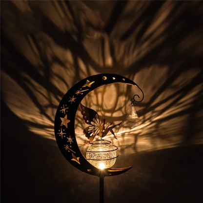 Decorative solar-powered fairy garden light with a glass globe and moon and fairy design for outdoor illumination