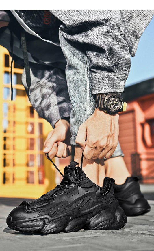 Pair of white, black, and gray casual sports sneakers with leather upper and rubber sole