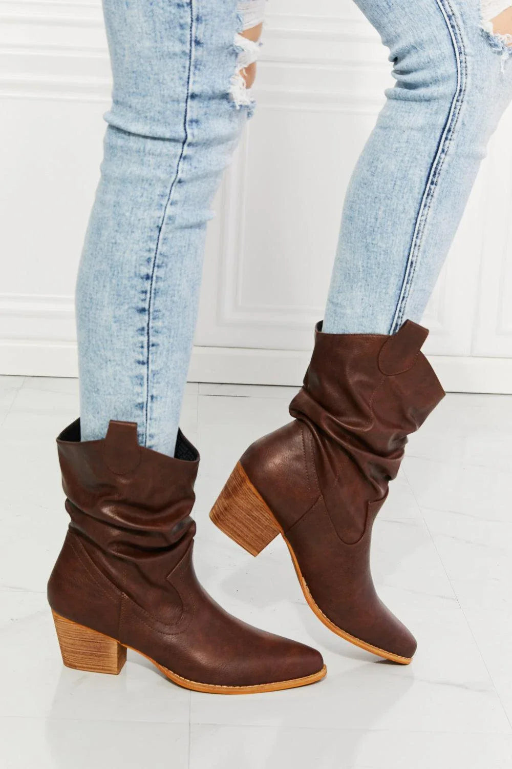 A pair of brown scrunch cowboy boots with a wooden sole, showcasing a sophisticated and stylish design perfect for Kiwi fashion.