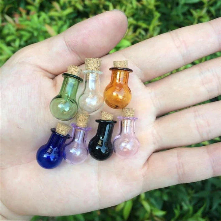 Multicoloured mini glass bottles in a stylish ball shape, perfect for essential oils, trinkets, and decorative accents.