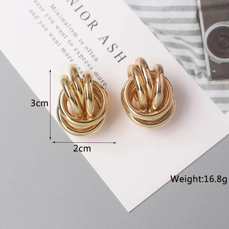 Geometric statement earrings in a luxurious gold finish, featuring a unique hollow twist design for a bold, fashionable look