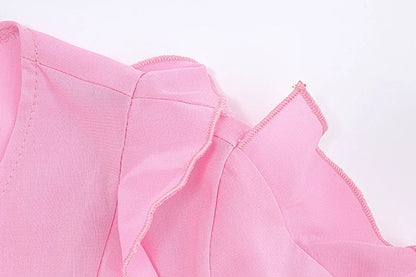 A pink ruffled crop top with a heart-shaped bow accent, made from stretch chiffon fabric for the modern Kiwi girl's style.