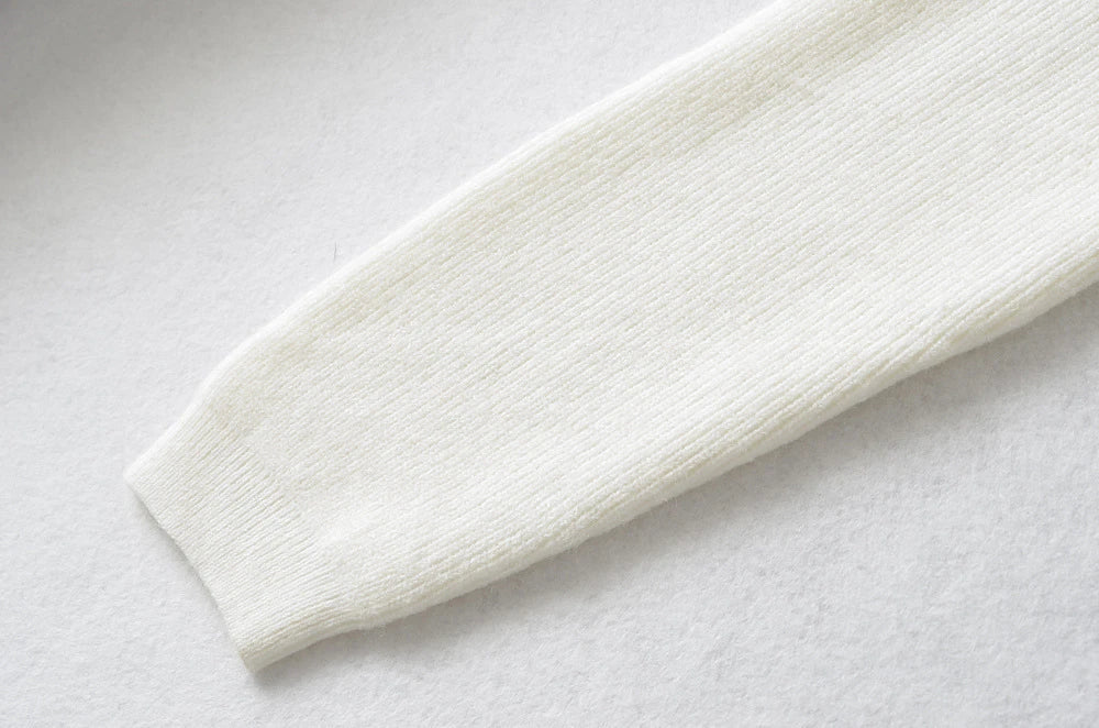 Stylish knitwear vest in a classic black or neutral colour, featuring a V-neck collar and long sleeves for a polished, versatile look.