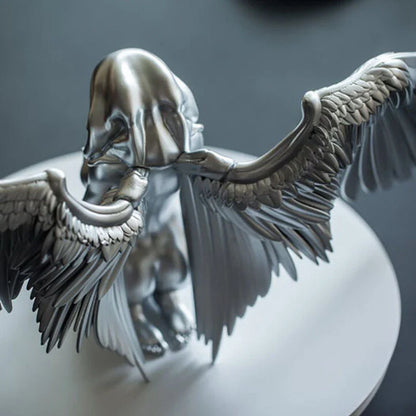 A silver resin ornament featuring the graceful silhouette of angel wings, perfect for adding a touch of Kiwi charm to your home decor.