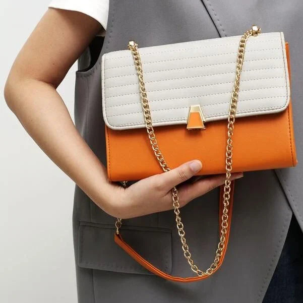 Stylish quilted vegan leather shoulder bag in orange color with unique lock and chain decoration