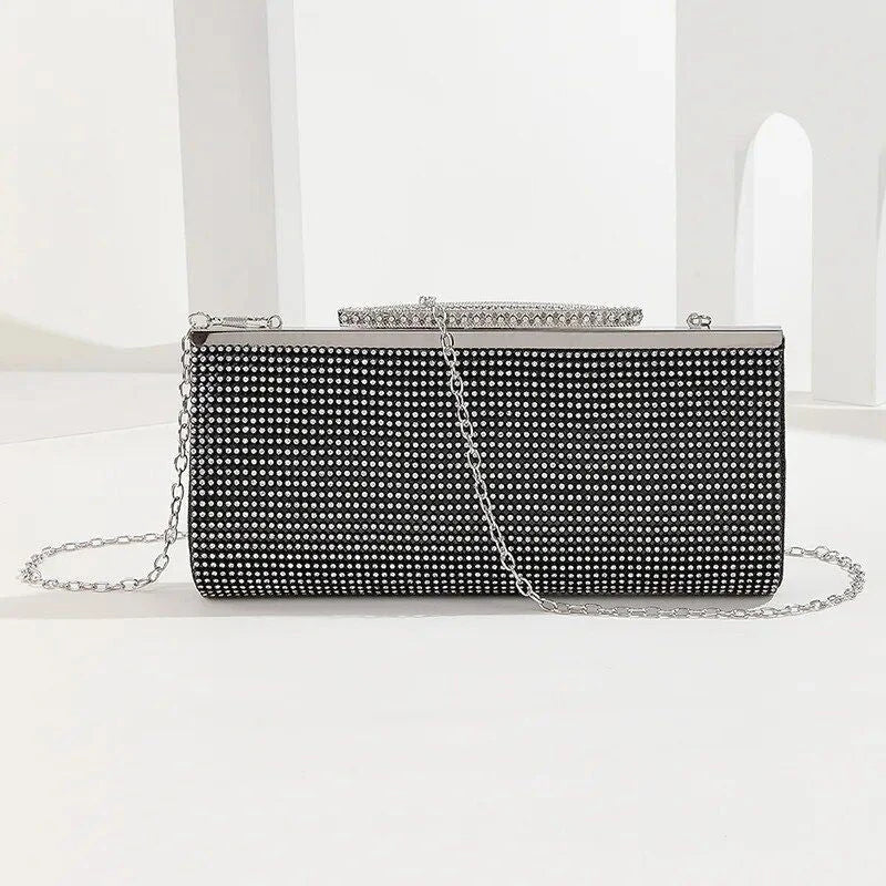 A glamorous gold rhinestone-embellished evening clutch with a sleek, hard exterior and fashionable hasp closure.