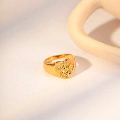 Closeup of a gold plated stainless steel ring with a heart and angel design, a classic and elegant accessory