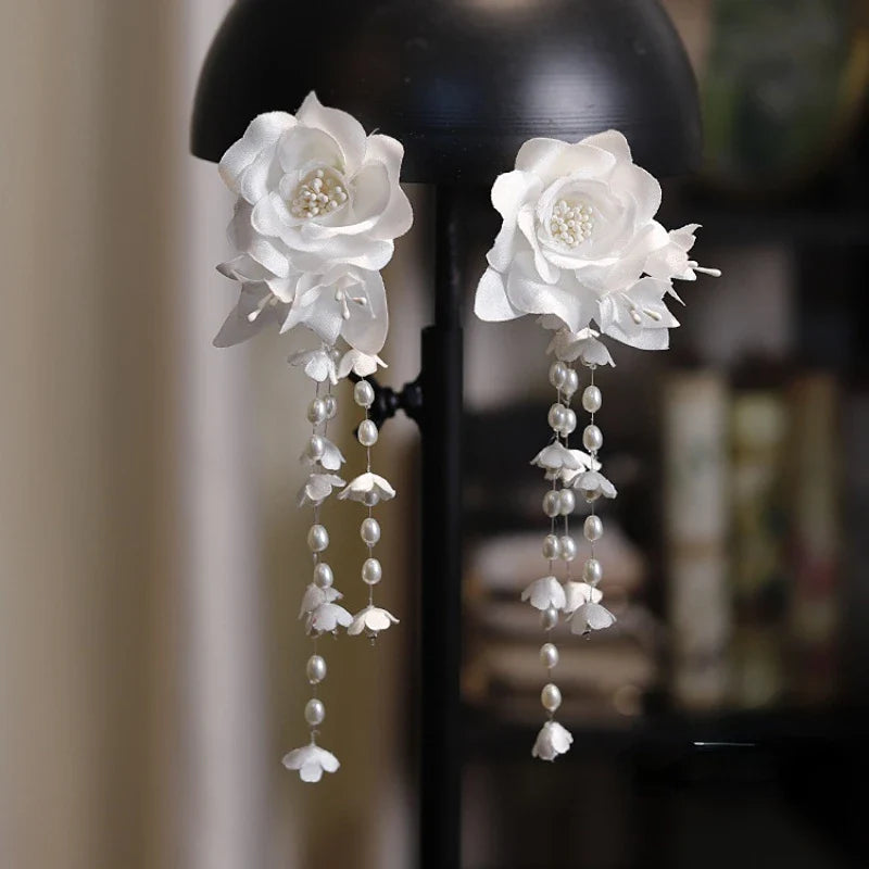 Elegant white floral ear clip with three-dimensional camellia flower and lily of the valley bud