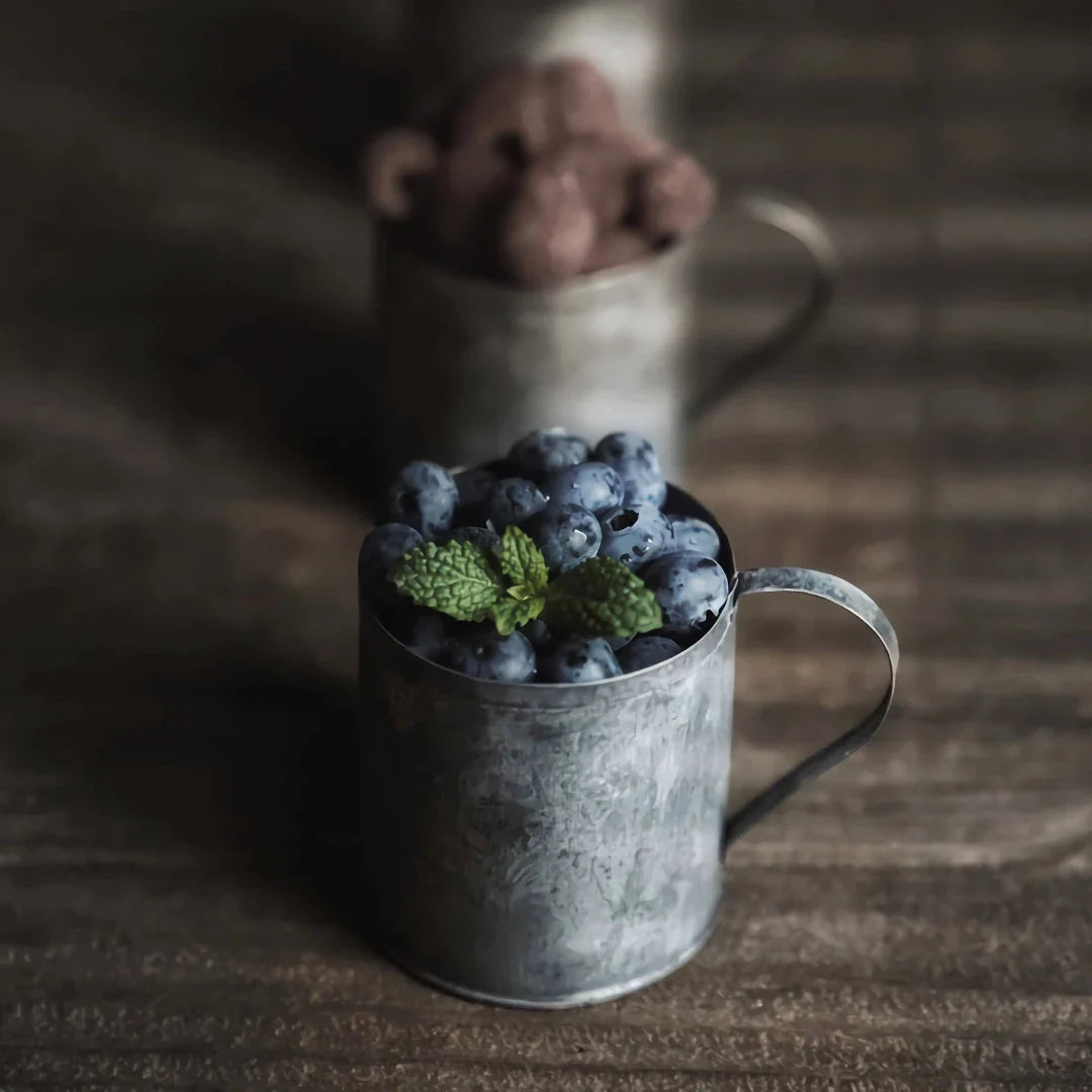 Vintage-inspired metal beverage cup with a charming wrought iron handle, perfect for serving desserts, fruits, and snacks