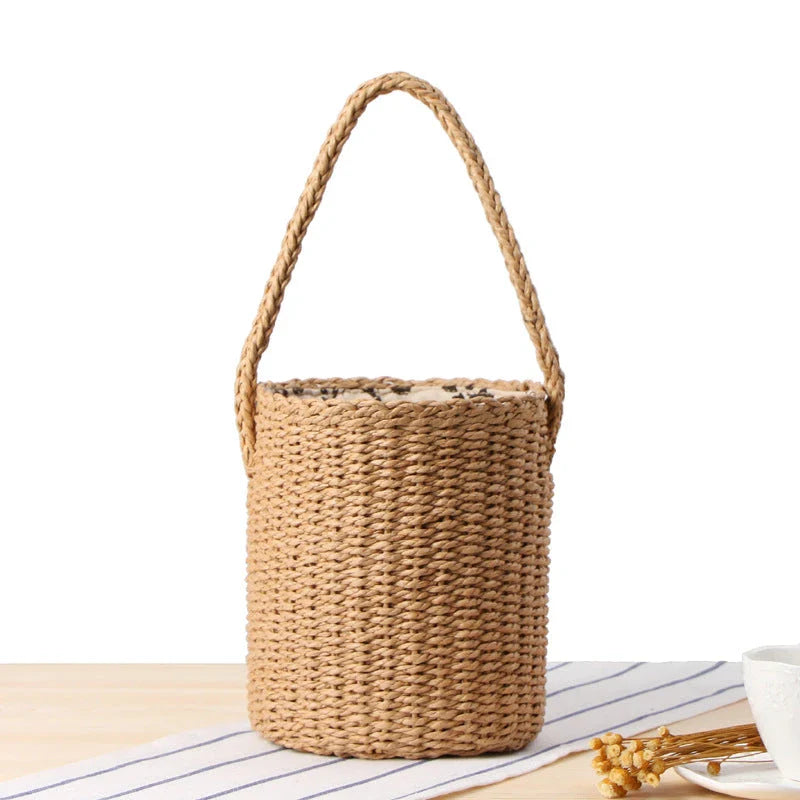 Hand-crafted straw bucket bag in camel and beige colors, featuring a compact and lightweight design for everyday Kiwi summer use