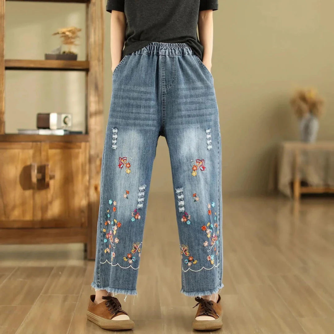 Embroidered wide-leg denim pants with a high-waist design and elastic closure, perfect for Kiwi fashion.