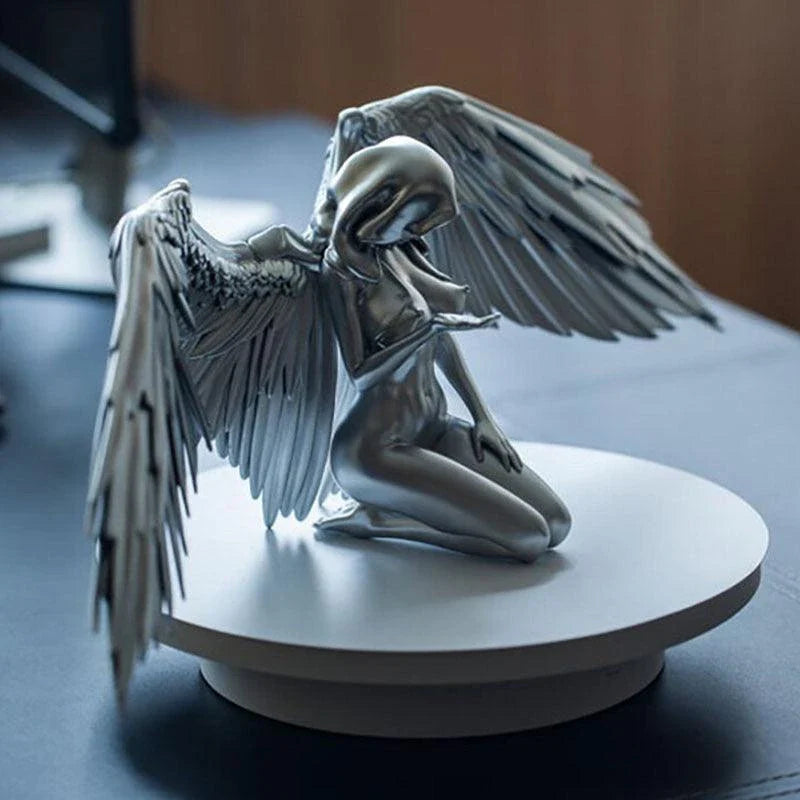 A silver resin ornament featuring the graceful silhouette of angel wings, perfect for adding a touch of Kiwi charm to your home decor.