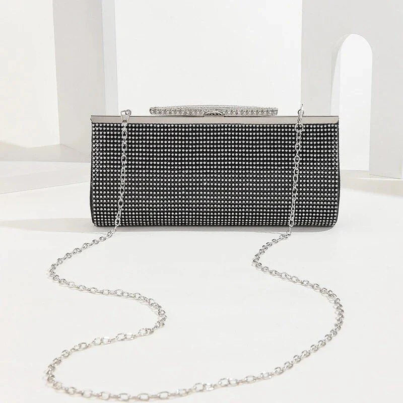 A glamorous gold rhinestone-embellished evening clutch with a sleek, hard exterior and fashionable hasp closure.