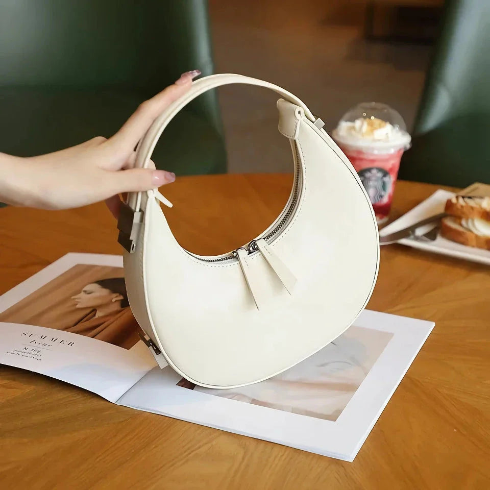 Elegant leather shoulder bag in a half-moon shape, perfect for Kiwi fashion