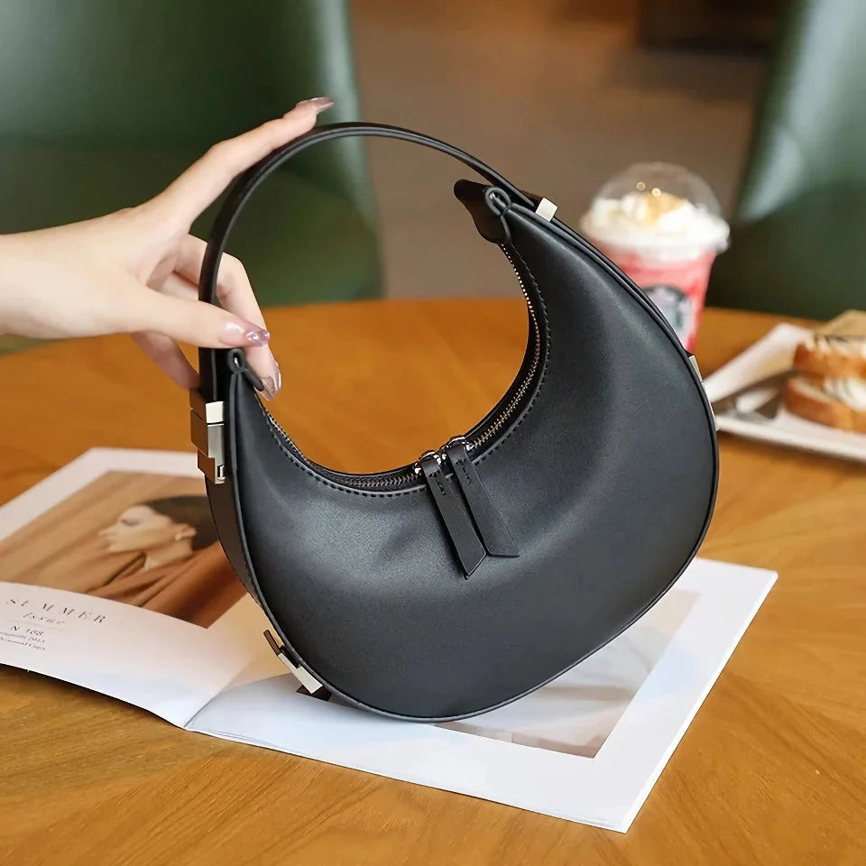 Elegant leather shoulder bag in a half-moon shape, perfect for Kiwi fashion