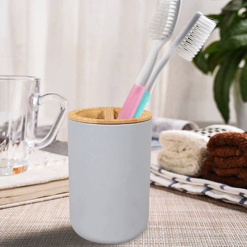 A 6-piece bamboo bathroom accessory set with a trash can, toilet brush, lotion bottle, soap box, toothbrush holder, and mouth cup