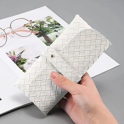 Stylish black and white twist braided leather sunglasses case with snap closure, protecting eyewear in a fashionable way