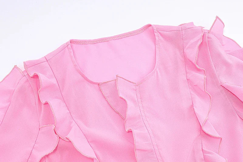 A pink ruffled crop top with a heart-shaped bow accent, made from stretch chiffon fabric for the modern Kiwi girl's style.