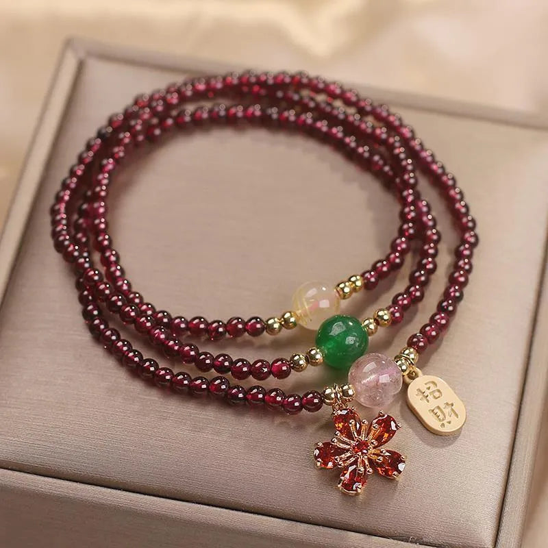 Natural crystal bracelet for women in pomegranate red cherry blossom colour with sequin detailing.
