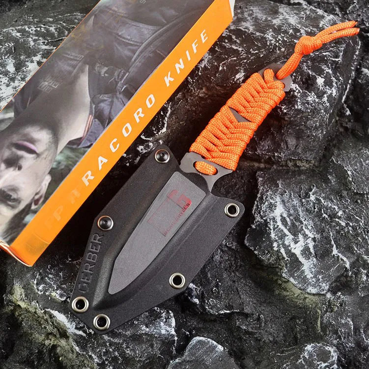 Straight survival knife with rope handle and black ABS sheath on a paper box.