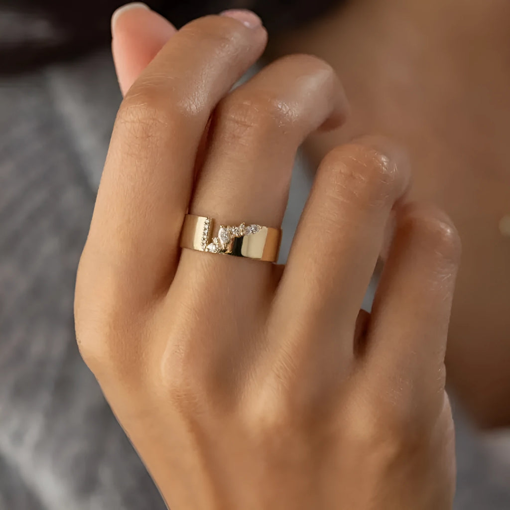 Gold-coloured women's fashion ring with shining zircon stones on a metal band