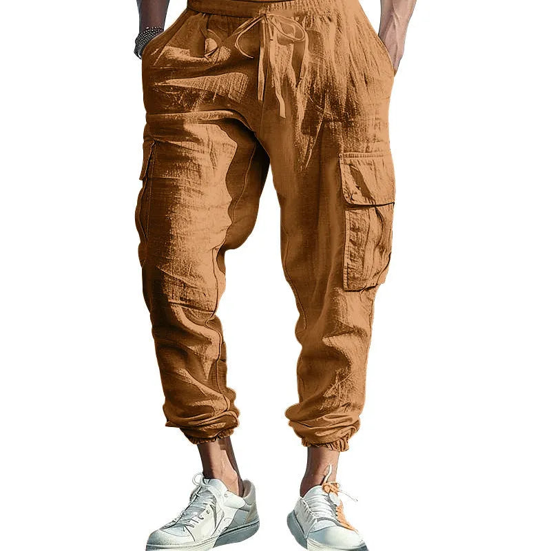 Man wearing loose khaki linen trousers with ankle-tied cuffs, drawstring waist, and multiple pockets.