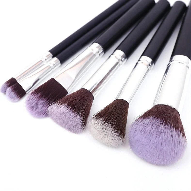 12 makeup brushes with pink handles and black bristles arranged in white storage bucket