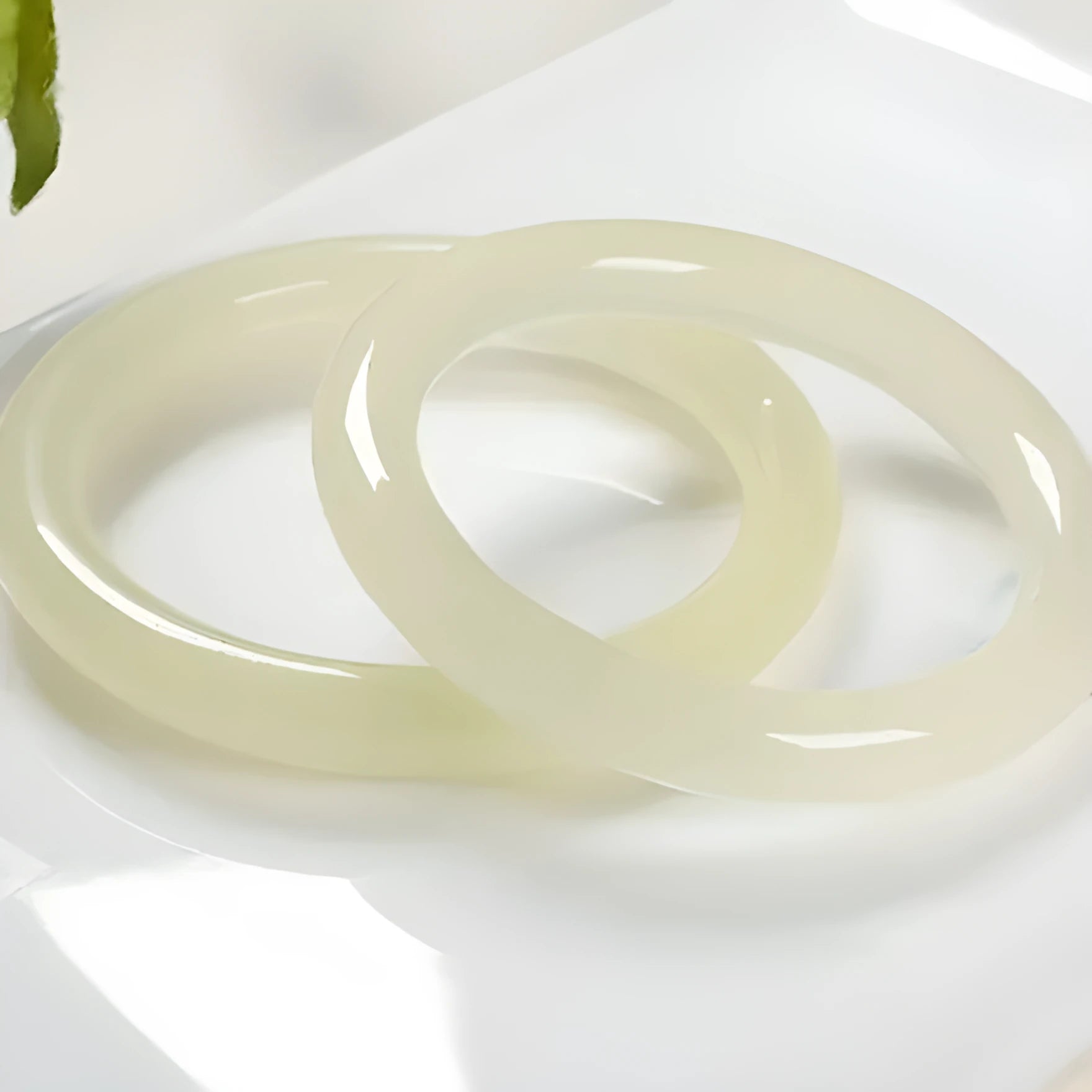 Polished ice-like silk jade round bar bracelet showing its geometric shape and smooth surface