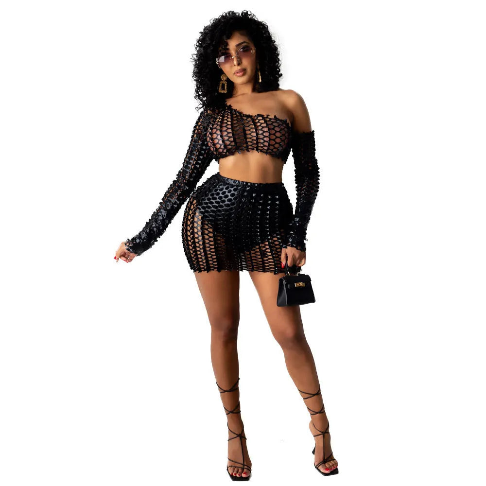 Women's black hollow-out net top and matching short skirt two-piece set on a model.