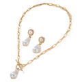 Gold tone retro style necklace and matching pearl ear studs set for women on a flat surface.